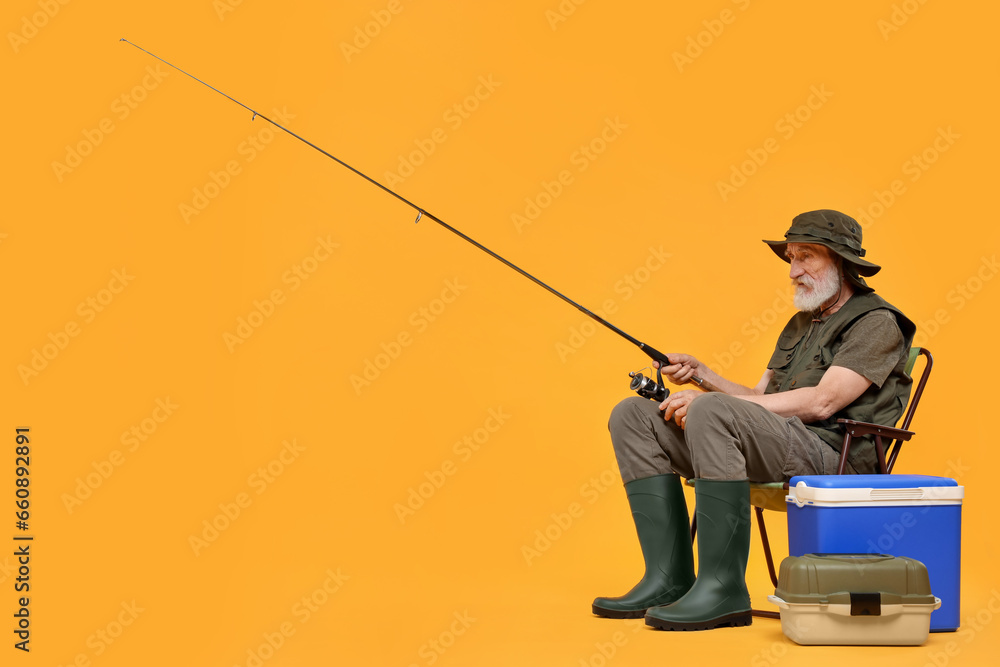 Fisherman with fishing rod on chair against yellow background, space for text Fisherman with fishing rod on chair against yellow background, space for text