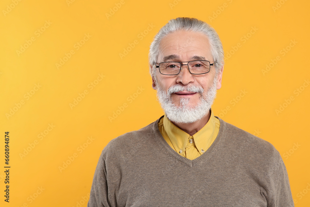 Portrait of handsome senior man in eyeglasses on orange background Portrait of handsome senior man in eyeglasses on orange background