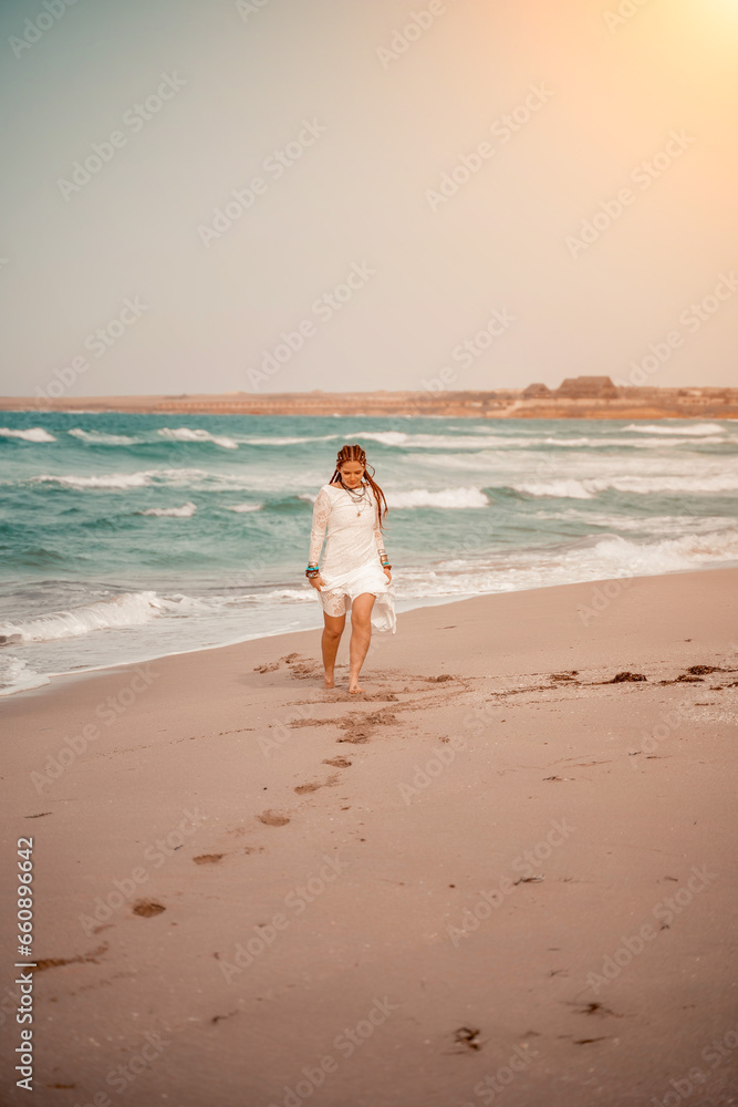 woman sea white dress. Model in boho style in a white long dress and silver jewelry on the beach. Her hair is braided, and there are many bracelets on her arms. woman sea white dress. Model in boho style in a white long dress and silver jewelry on the beach. Her hair is braided, and there are many bracelets on her arms.