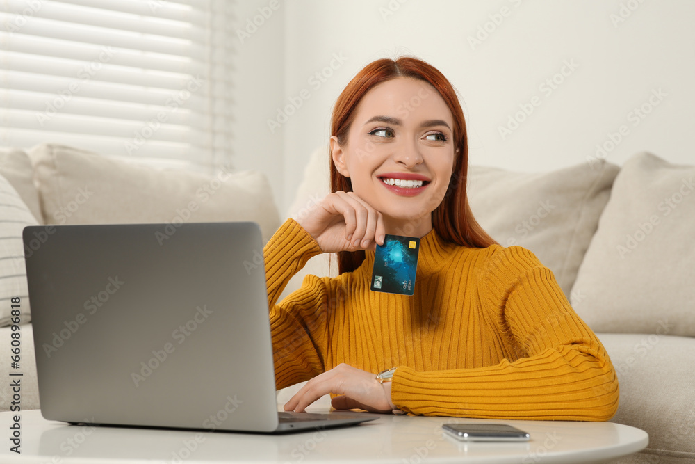 Happy woman with credit card near laptop at home. Online shopping Happy woman with credit card near laptop at home. Online shopping