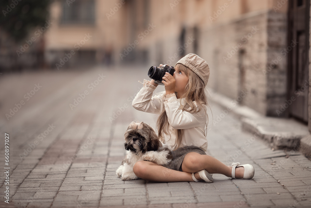 Little girl with camera and puppy taking photos on the streets of the city  - obrazy, fototapety, plakaty 