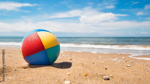 Colorful beach ball on sunny sandy beach with blue sky and sea