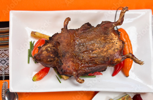 Traditional Peruvian roasted cuy (guinea pig) with vegetables photo