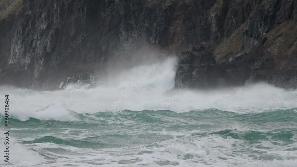 Powerful And Dangerous Waves Hitting The Rocky Cliff During Typhoon In Sandfly Bay, Dunedin, New Zealand. - close up Powerful And Dangerous Waves Hitting The Rocky Cliff During Typhoon In Sandfly Bay, Dunedin, New Zealand. - close up