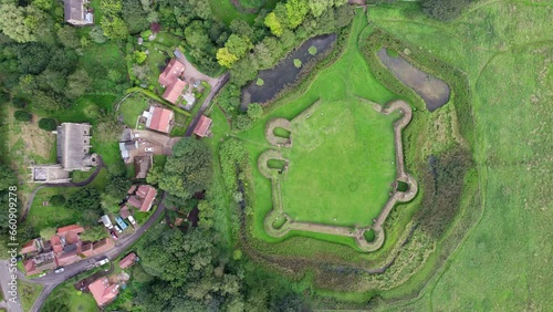 Aerial video footage of the remains of Bolingbroke Castle a 13th century hexagonal castle, birthplace of the future King Henry IV, with adjacent earthwork. and views of Old Bolinbroke Village. photo