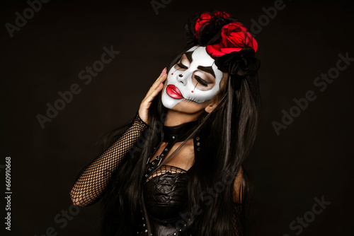 Portrait of a woman with sexy skull makeup over black background. Halloween costume and make-up. Portrait of Calavera Catrina