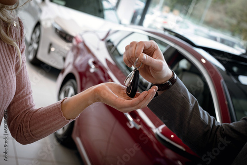 Buy a car conceptual background. Give a new car keys in a car salon