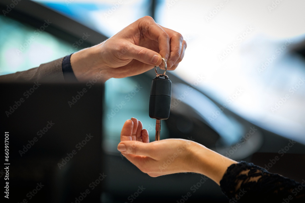 Buy a car conceptual background. Give a new car keys in a car salon Buy a car conceptual background. Give a new car keys in a car salon