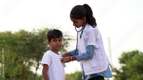 Female doctor or pediatrician with stethoscope listening to heartbeat boy's patient on medical exam at clinic. © Govind