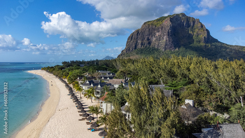 Le Morne tropical beach and famous kite, surf spot aerial panoramic view with palm trees and white sand blue ocean and sunbeds with umbrellas, Mauritius