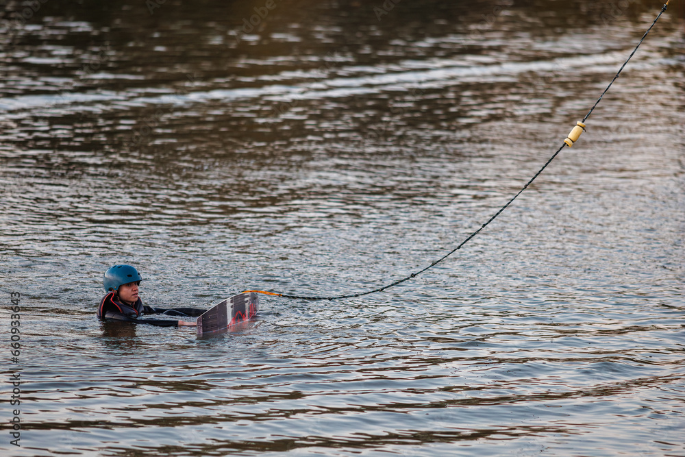Girl on a wakeboard. An athlete performs a trick on the water. Autumn Park Girl on a wakeboard. An athlete performs a trick on the water. Autumn Park