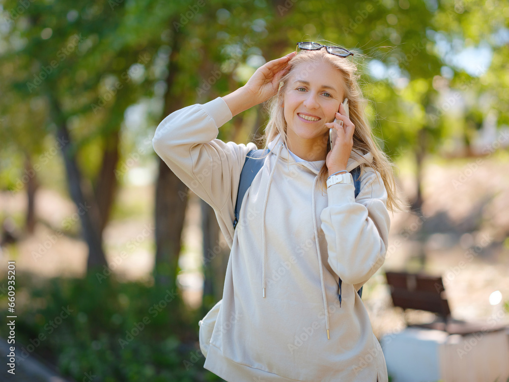Portrait of cute woman in with smartphone in park.