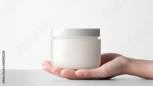 Woman holds a jar of beauty cream in her hand on a white background.