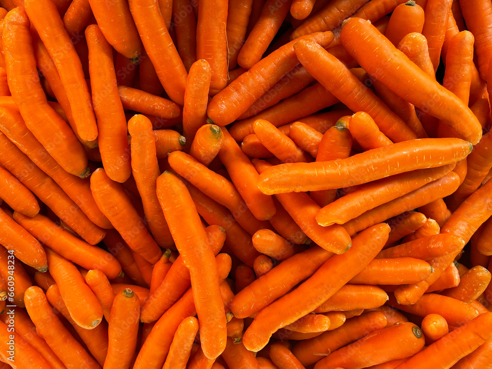A pile of carrots for sale, close-up as a background. Lots of carrots on the farmer's market stand. Local harvest, organic products at Laiki Agora on the streets of Athens, Greece. A pile of carrots for sale, close-up as a background. Lots of carrots on the farmer's market stand. Local harvest, organic products at Laiki Agora on the streets of Athens, Greece.
