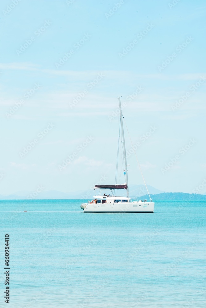 Tranquil blue sea with a cruise boat in clear weather in Phang Nga Bay, Phuket, Thailand.