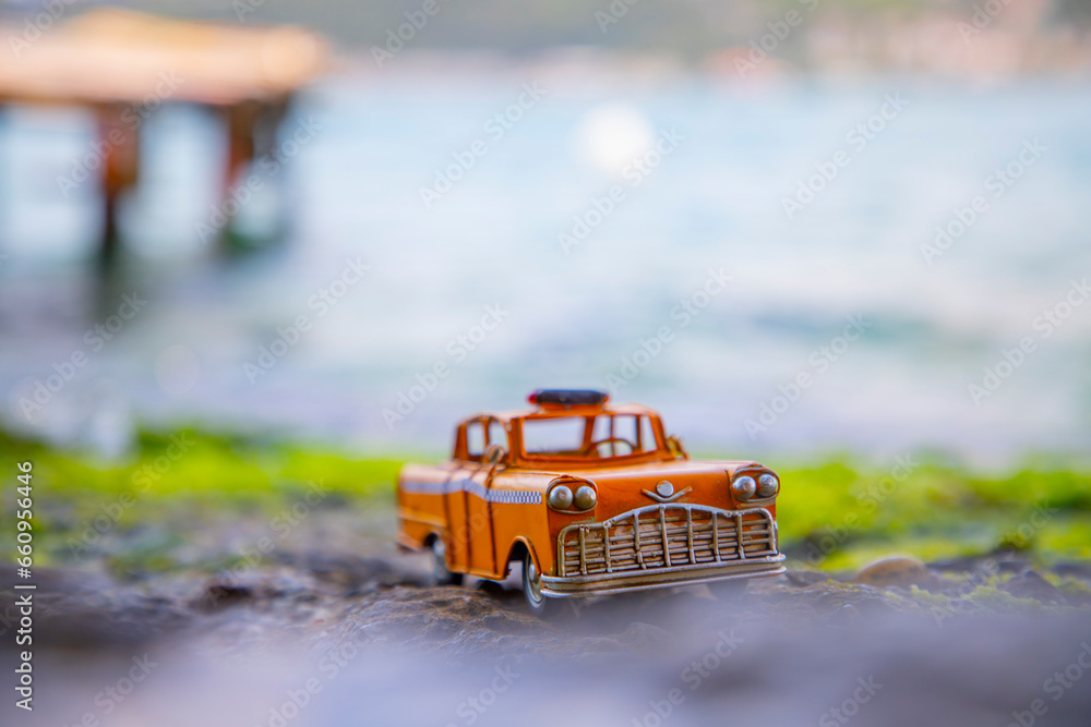 Model yellow taxi left on the beach