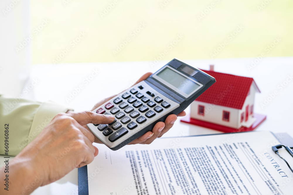 Hand of Business people calculating interest, taxes and profits to invest in real estate and home buying Hand of Business people calculating interest, taxes and profits to invest in real estate and home buying