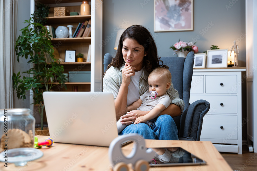 Young female business owner work on laptop from home during maternity leave, running private company with baby in her lap. Businesswoman mother woman with a toddler working at the computer. Young female business owner work on laptop from home during maternity leave, running private company with baby in her lap. Businesswoman mother woman with a toddler working at the computer.