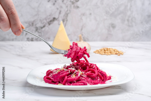 Cooked Barbie pasta on a fork over a white plate with pasta. photo