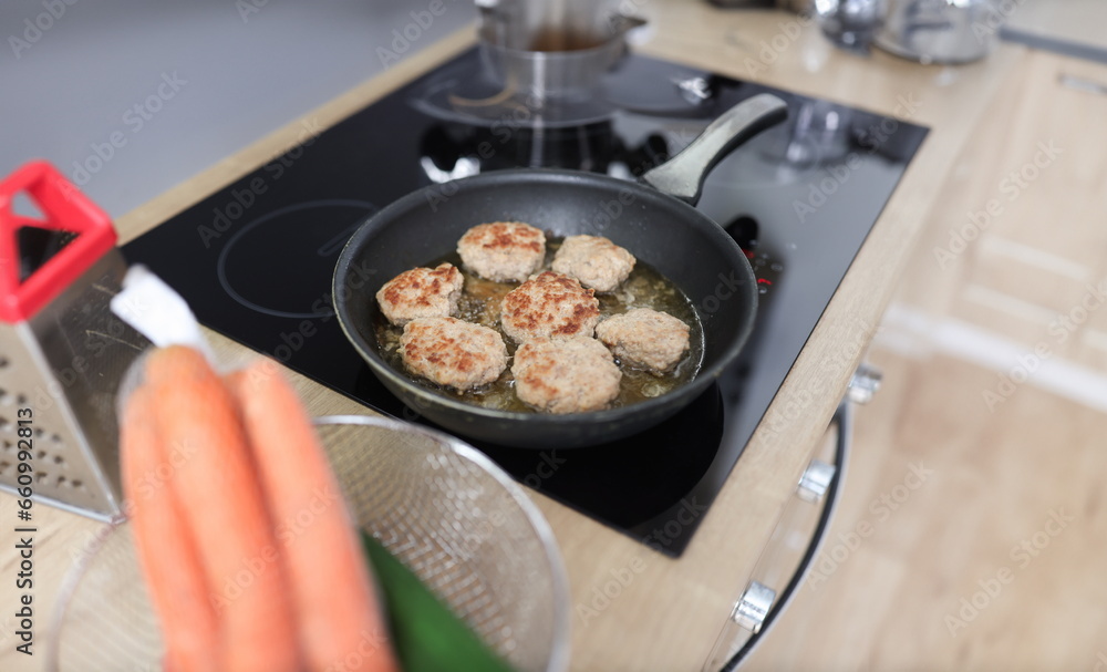 In kitchen, cutlets are fried in frying pan. Home cooking concept In kitchen, cutlets are fried in frying pan. Home cooking concept