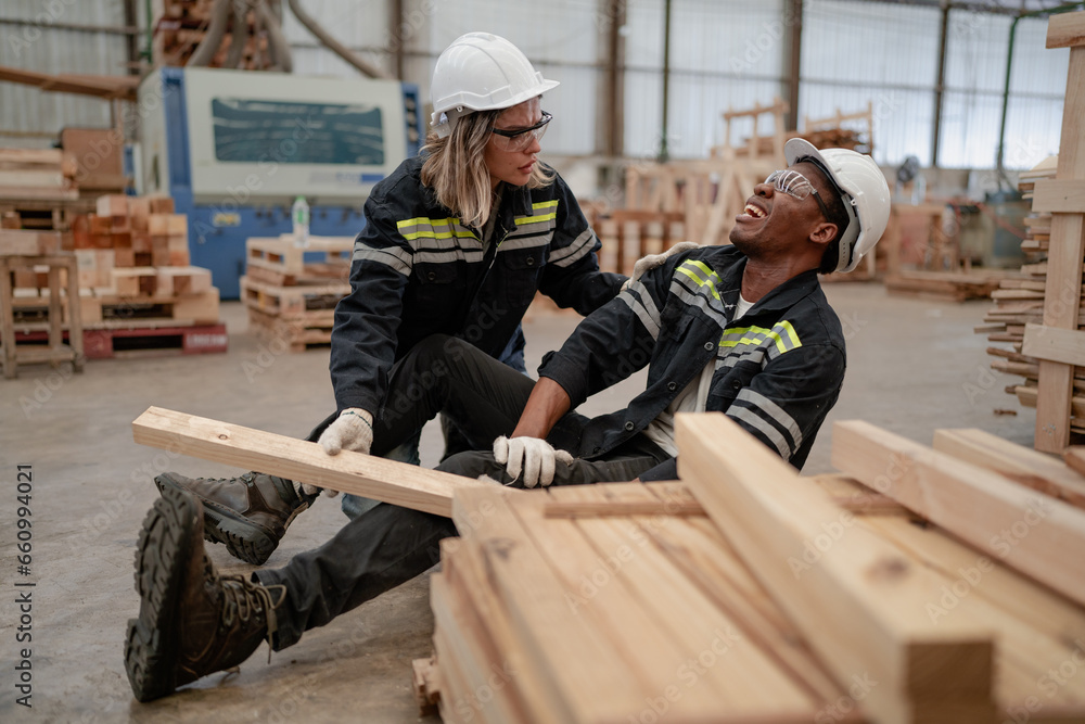 Foreman injured from accident lying on floor crying with pain in warehouse. Female worker emergency help male colleague who falling down get physical injury in workplace. Risk, dangerous in workplace