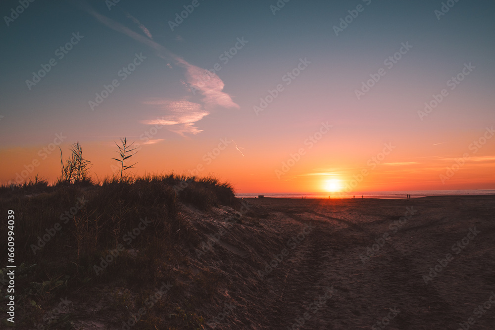 Sunset with dunes and beach in foreground