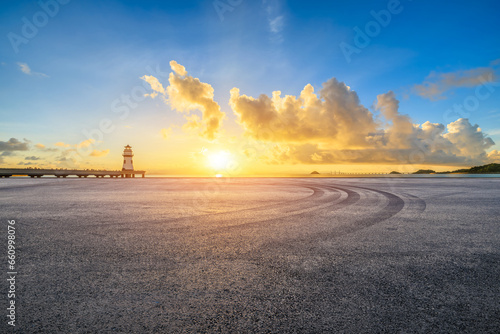 Asphalt road and lighthouse scenery at sunrise by the sea  Zhuhai  Guangdong Province  China.