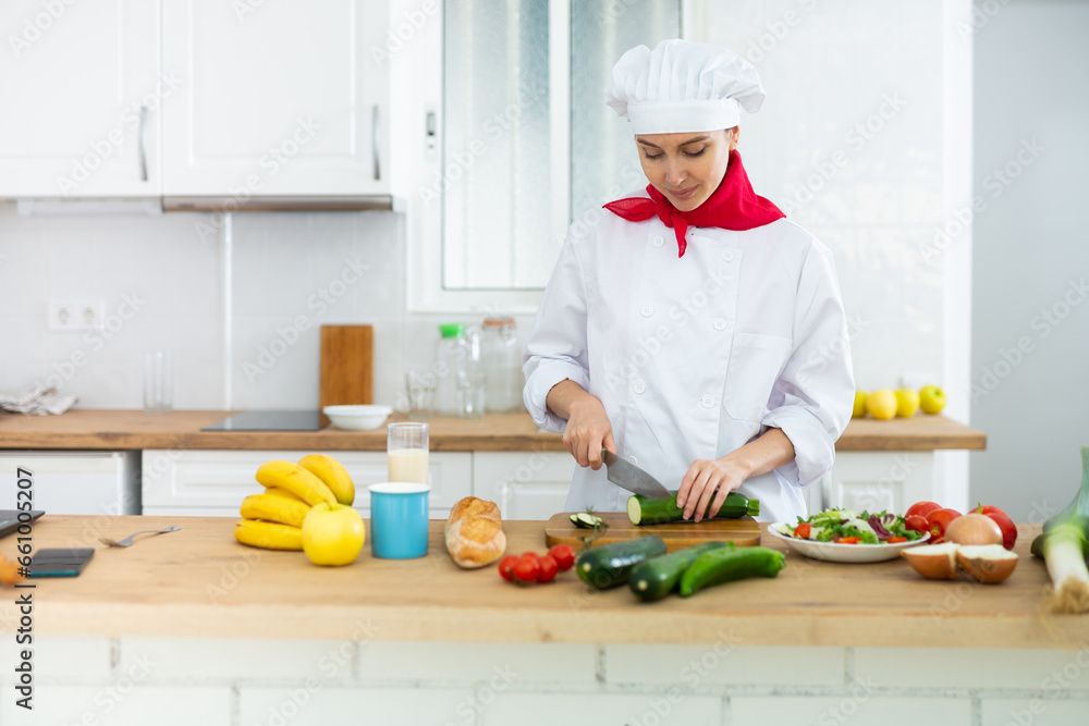 Proffesional woman cook in white uniform chopping vegetables Proffesional woman cook in white uniform chopping vegetables