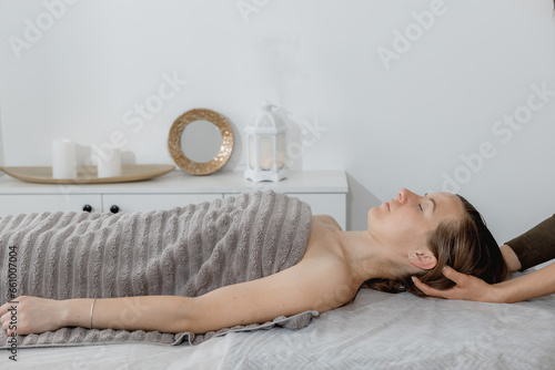 buccal facial and neck massage, close-up, cosmetologist makes woman a procedure on a massage table in a spa salon