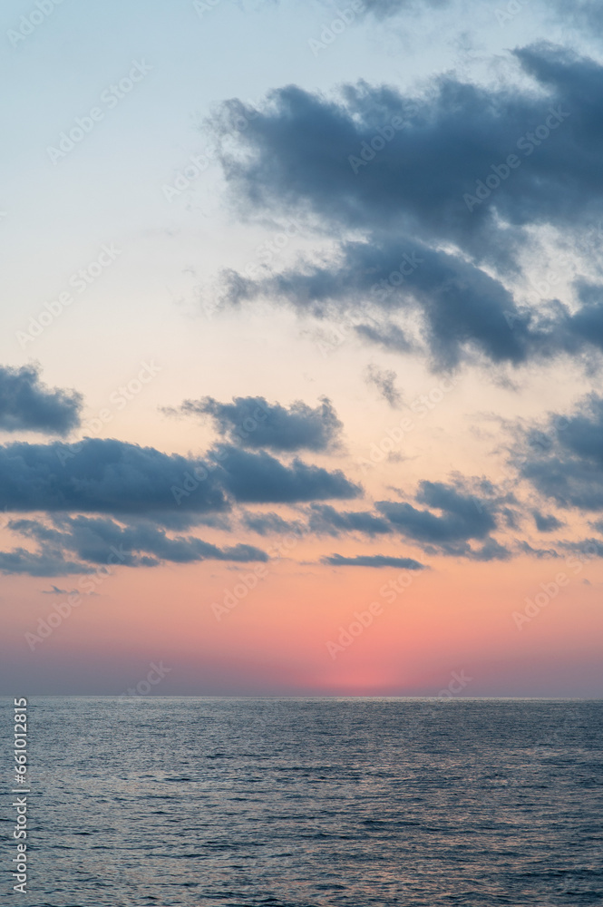 Beautiful sky with clouds over the sea after sunset. Vertical photo