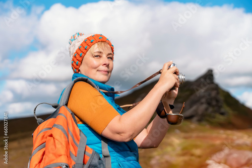 Woman reaching the destination and taking selfie, photos, and shouting on the top of mountain Travel Lifestyle concept The national park Peak District in England
