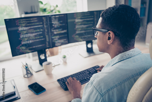 Side profile photo of serious man hardware expert sitting chair keyboard writing open space program system watch monitors in office