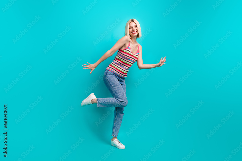 Full length photo of cheerful positive girl dressed striped tank top dancing having fun isolated teal color background