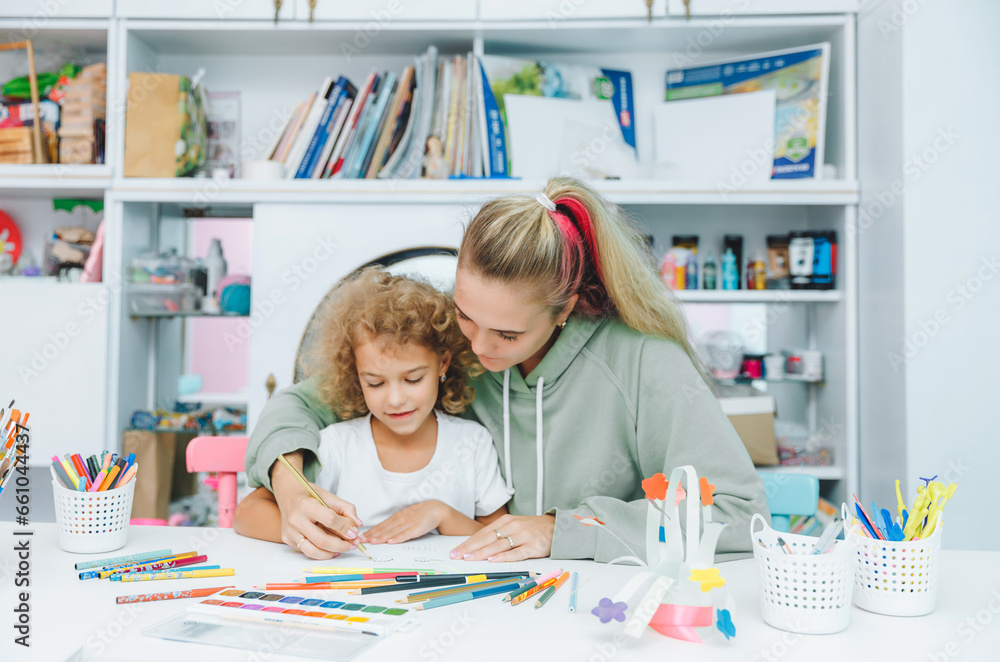 Fototapeta premium mother and child draw. daughter is engaged in creativity. mother and daughter paint.