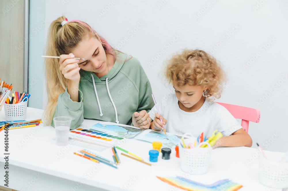 mother and child draw. daughter is engaged in creativity. mother and daughter paint. mother and child draw. daughter is engaged in creativity. mother and daughter paint.