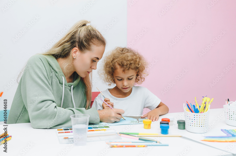 mother and child draw. daughter is engaged in creativity. mother and daughter paint. mother and child draw. daughter is engaged in creativity. mother and daughter paint.