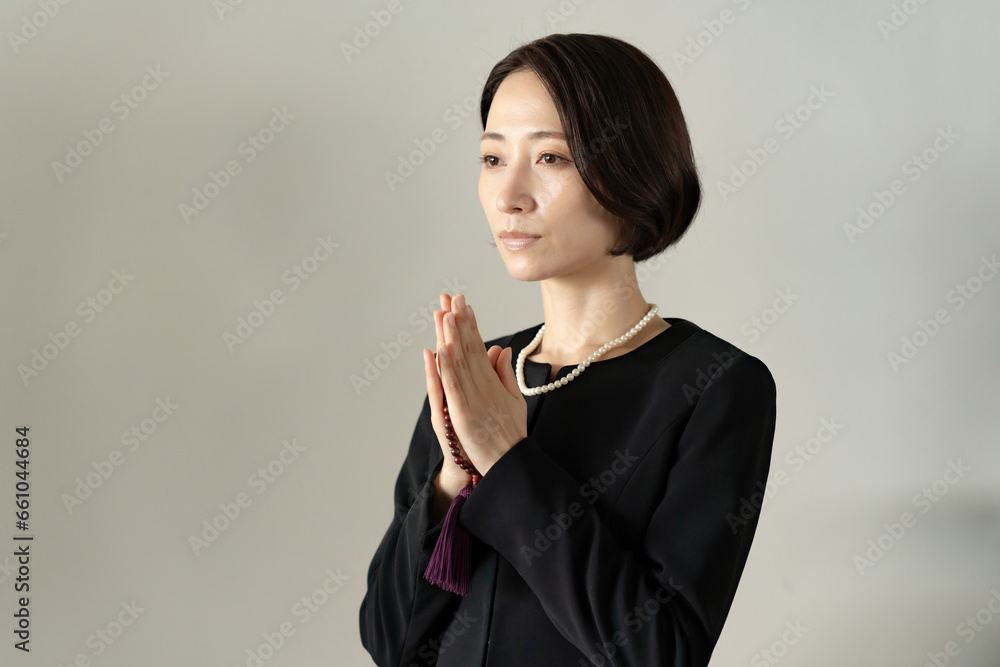 お葬式で手を合わせる女性 お葬式で手を合わせる女性