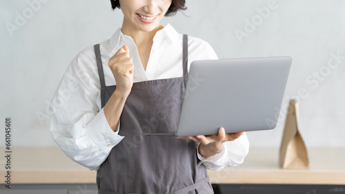 パソコンで注文を確認するカフェ店員 photo