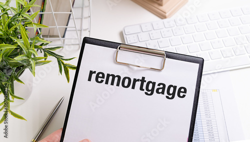 Text remortgage on white paper sheet and marker on businessman hand on the diagram. Business concept photo