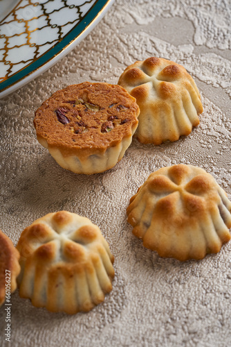 A close-up photo of pieces of Syrian Eid sweets (maamoul) stuffed with dates