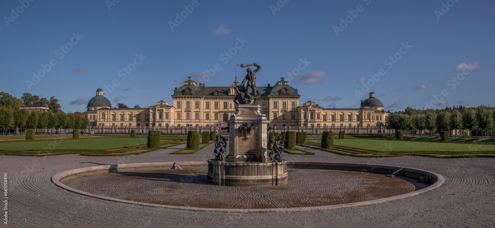Fototapeta premium Statue and castle and park in the Drottningholm island, autumn colors tree, a sunny day in Stockholm