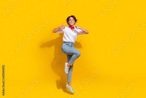 Full length photo of satisfied overjoyed girl wear trendy fly air hand thumb up good job nice feedback isolated on yellow color background
