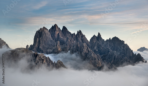 Mountain landscape with fog, at sunset Dolomites at Tre Cime hiking path area in South Tyrol in Italy.