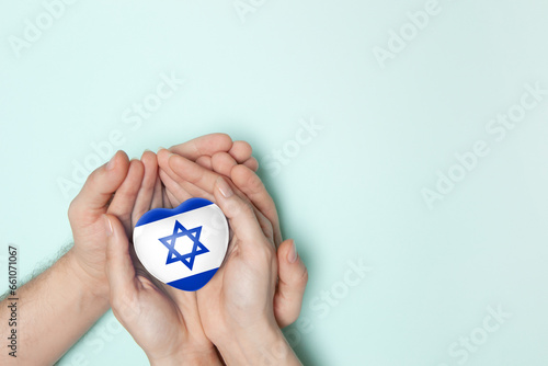 Heart with print of Israel flag in female and male hands.. Flat lay. Copy space.