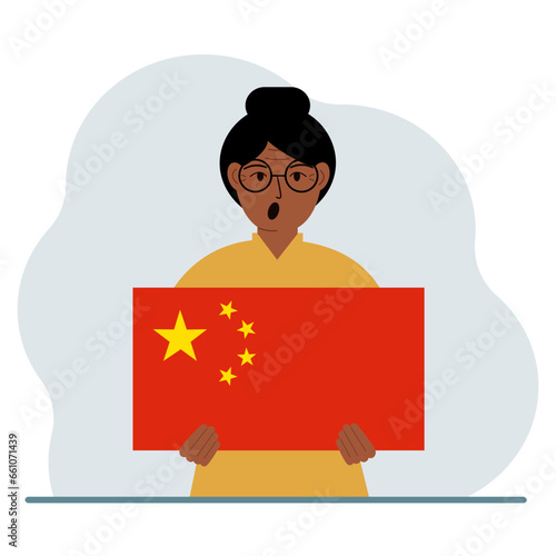 A woman holds a Chinese flag. The concept of demonstration, national holiday or patriotism. Nationality.
