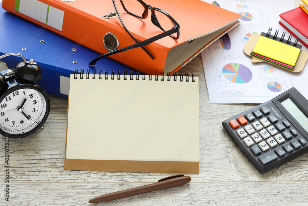 office desk background with glasses on an orange folder, blank notepad, calculator, desk clock and supplies. space for text on the page. Top view, business background office desk background with glasses on an orange folder, blank notepad, calculator, desk clock and supplies. space for text on the page. Top view, business background