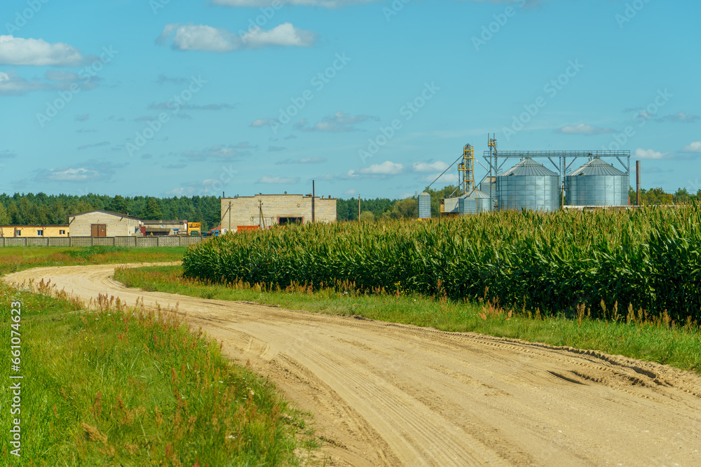 silver silos on agro manufacturing plant for processing drying cleaning and storage of agricultural products, flour, cereals and grain. Large iron barrels of grain. Granary elevator silver silos on agro manufacturing plant for processing drying cleaning and storage of agricultural products, flour, cereals and grain. Large iron barrels of grain. Granary elevator