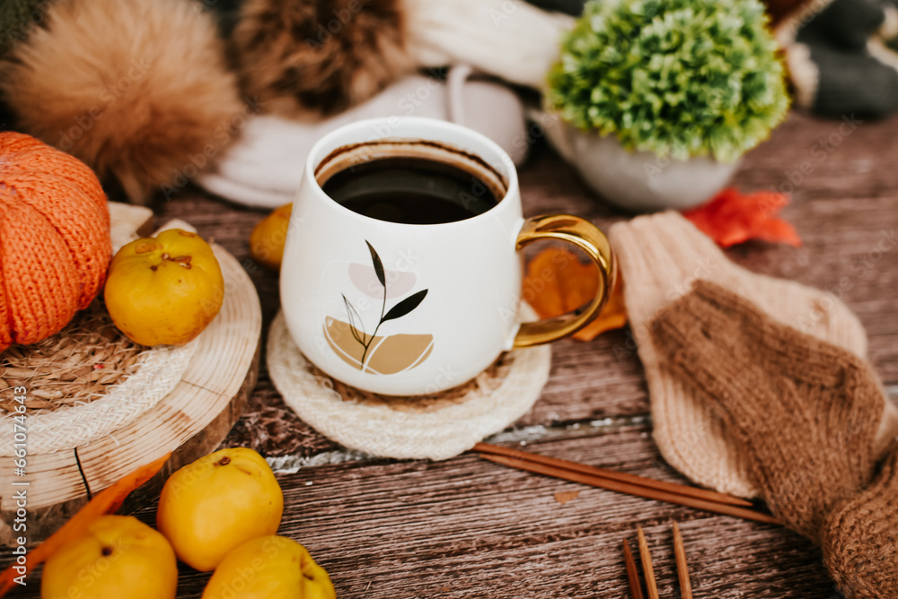 Cup of coffee with autumn leaves and knitted scarf on wooden background Cup of coffee with autumn leaves and knitted scarf on wooden background