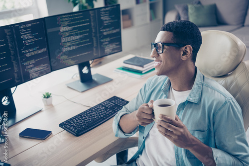 Photo of cheerful clever geek guy found tech solution developer it specialist coffee pause when he coding indoors workspace office