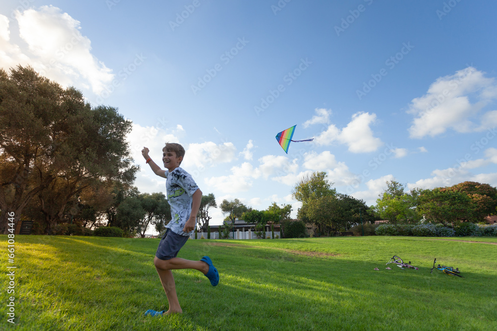 Happy child running with a rainbow kite Happy child running with a rainbow kite